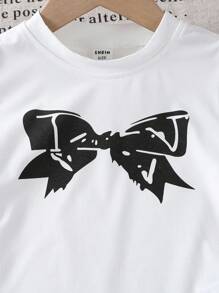 Camiseta infantil feminina com estampa de laço tricotado, gola redonda e detalhes em renda com babados. Ideal para o outono. - Branco - Ver 6