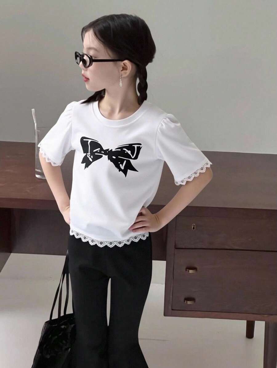 Camiseta infantil feminina com estampa de laço tricotado, gola redonda e detalhes em renda com babados. Ideal para o outono. - Branco - Ver 1