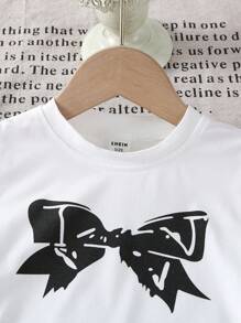 Camiseta infantil feminina com estampa de laço tricotado, gola redonda e detalhes em renda com babados. Ideal para o outono. - Branco - Ver 8