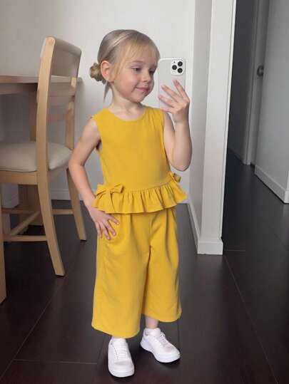 طقم للفتاة الصغيرة مكون من توب ذو رقبة مستديرة بلون أحادي بدون أكمام وبتزيينات كشكشة, وسروال كاجوال فضفاض محبوك