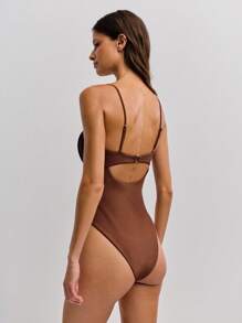 Nöista 这款棕色连体泳衣采用精致的细肩带设计，胸部柔软收拢，胸部下方采用大胆的镂空设计，打造时尚现代的时尚造型。时尚的廓形既彰显个性，也是夏季沙滩装的完美之选。 - 棕色 - 查看 2