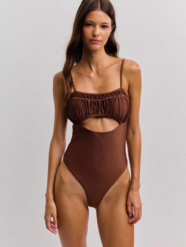 Nöista This Brown One Piece Swimsuit Features Delicate Spaghetti Straps, A Softly Gathered Bust, And A Bold Cut-Out Under The Bust For A Modern, Chic Look. The Sleek Silhouette Is Both Statement-Making And Perfect For Summer Beachwear.
