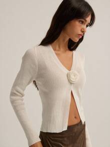 Nöista 这款针织开衫适合春秋季节较为凉爽的季节，可搭配裙子或牛仔裤。采用竖条纹针织面料，轻盈贴身。颜色为柔和的象牙白，整体纹理低饱和度。设计采用单颗立体编织花朵纽扣作为门襟，营造出简约而法式的浪漫气息。 - 白色 - 查看 4