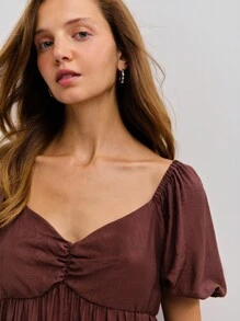 Nöista 这款棕色泡泡袖娃娃裙是秋季女装和返校季的舒适之选。宽松的版型和层叠的设计，非常适合乡村风、舒适的校服，或是想要展现可爱、舒适和时尚感的休闲秋日。