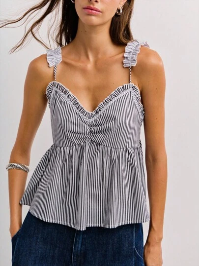 Nöista 这款黑白条纹荷叶边上衣采用荷叶边肩带和心形领口设计，营造出喇叭形廓形。它将复古魅力与 Y2K 街头潮流完美融合，是秋冬女性时尚的理想之选。