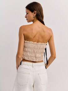 这款白色无肩带露脐上衣饰有黑色滚边、侧系带细节和轻微的荷叶边，体现了 Y2K 复古街头服饰与旧钱优雅的风格，是秋冬季女装的理想之选。 - 米色 - 查看 2