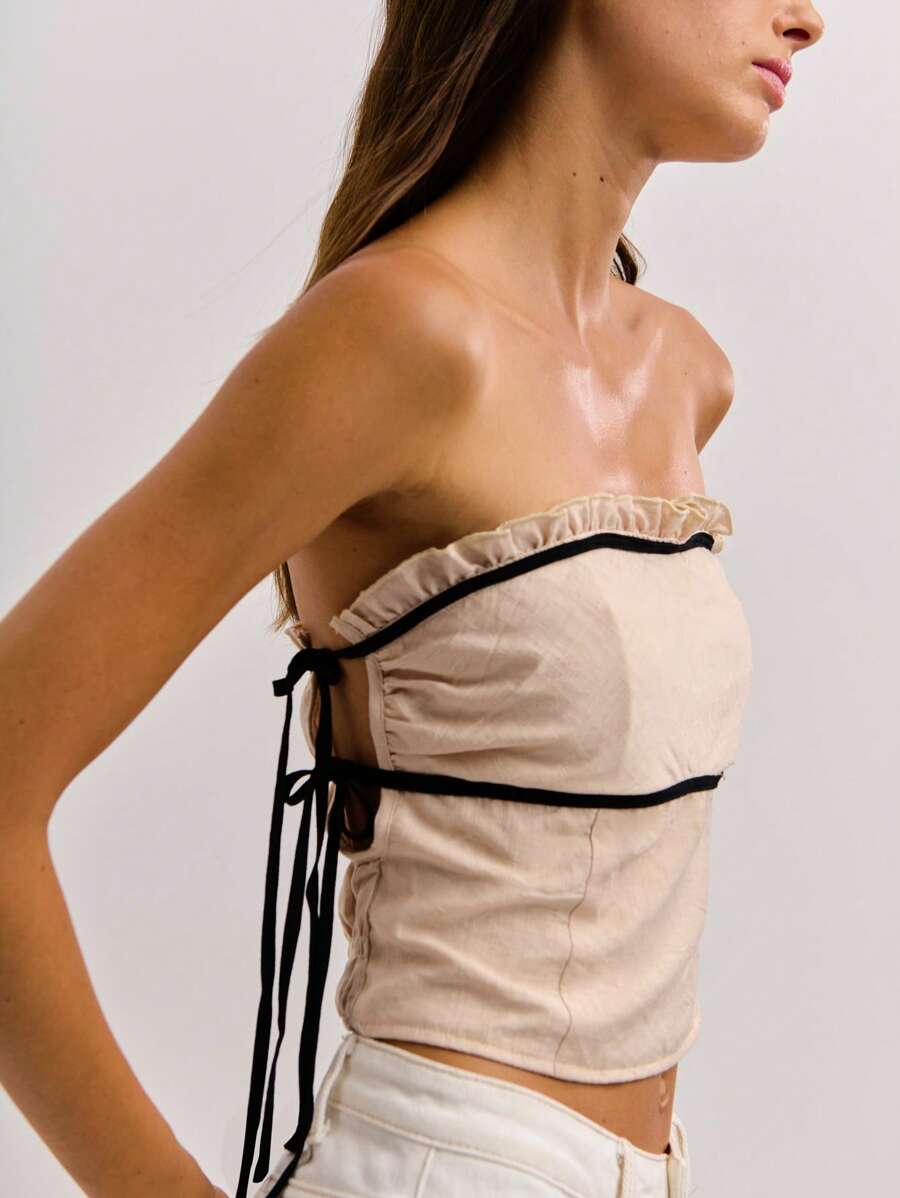 这款白色无肩带露脐上衣饰有黑色滚边、侧系带细节和轻微的荷叶边，体现了 Y2K 复古街头服饰与旧钱优雅的风格，是秋冬季女装的理想之选。 - 米色 - 查看 1