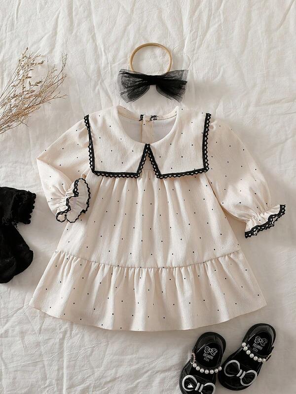 Souflis Souflis 女婴荷叶边领长袖A字裙，搭配薄纱蝴蝶结头饰。超大领口、泡泡袖和A字廓形，打造时尚经典造型。无论是外出还是居家休闲，小公主都能成为众人瞩目的焦点。