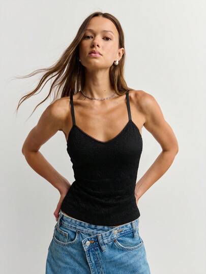  Nöista Black Textured Cami In Stretch Waffle Knit Blends Minimalist Allure With Gothic Glamour: Slender Spaghetti Straps Frame A Subtle V-Neckline, While The Figure-Hugging Silhouette And Lightweight, Breathable Knit Make This Black Waffle Cami A Night-Out Essential, Festival Layer, And Everyday Wardrobe Staple For Seamless Y2K, Goth-Inspired, And Streetwear Looks.