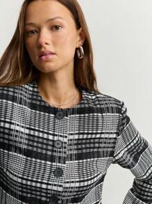 Nöista Chaqueta a cuadros en blanco y negro con mangas largas y botones grandes, ideal para el otoño o estilos de negocios casuales atemporales en invierno.