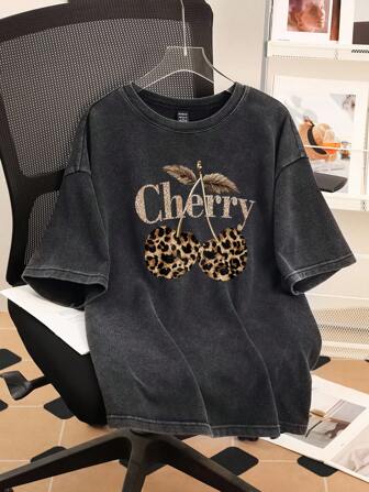 Attitoon T-shirt graphique minimaliste décontracté pour femmes avec imprimé léopard et motif cerise. Convient pour la plage, les festivals de musique, les vacances, le style "Miami Girl", vintage, grunge punk, la rentrée scolaire. T-shirt oversize mélangé noir