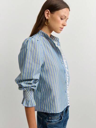 Nöista Camisa de rayas verticales azul y amarilla con cuello mao, mangas abullonadas largas, volante delantero y puños con fruncido. Perfecta para añadir un toque de inspiración vintage, ideal para looks chic de día y se combina fácilmente con faldas o pantalones.