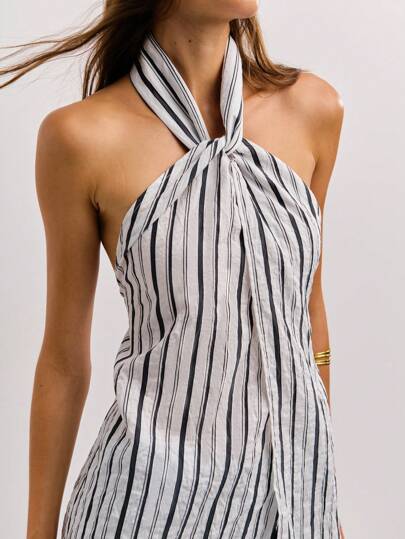 Nöista 这款黑白条纹露背上衣采用不对称单袖设计，后系带配有小纽扣，融合了复古和 Y2K 街头风格，适合秋冬女装时尚。