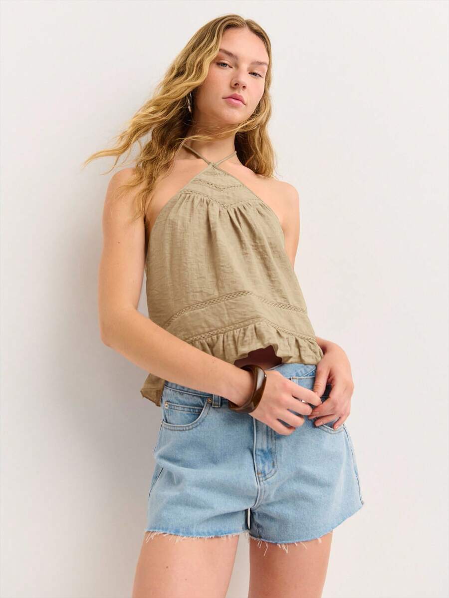 Nöista Top con peplum de halter en tela suave con detalles de encaje sutil. Ligero y fresco para salidas de verano, perfecto para looks del 4 de julio o vibraciones del Festival de San Juan.