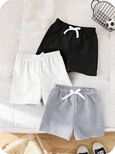 SHEIN Set de 3 pantalones cortos casuales y deportivos para niños, con diseños de rayas y unicolor, en un paquete de 3 por el precio de 2. Adecuado para fiestas, eventos, ceremonias, escuela, viajes, deportes y uso diario en primavera y verano.