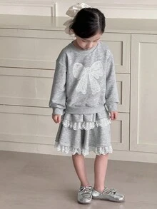SHEIN 两件套女童刺绣蝴蝶结圆领卫衣和蕾丝拼接A字裙套装，休闲韩版风格，适合春、秋、冬三季返校季穿着。女童秋季服装，包括荷叶边半裙、长袖卫衣等，适合年轻女孩穿着。另有蝴蝶结卫衣、灰色卫衣半裙套装和蕾丝边饰套装可供选择。 - 灰色 - 查看 6