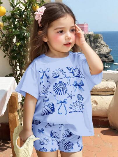 SHEIN Bộ đồ thể thao cho bé gái gồm áo thun tay ngắn cổ tròn dáng rộng và quần short bó sát in hình sinh vật biển dễ thương, vỏ sò và nơ, thích hợp cho mùa xuân/hè.
