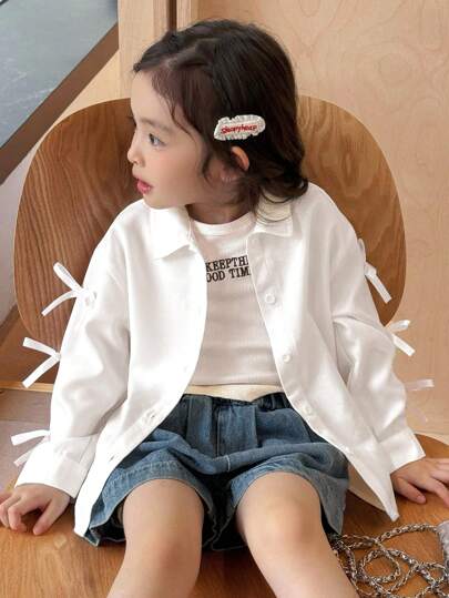 SHEIN 女童长袖休闲舒适衬衫，饰有蝴蝶结细节。女童白色衬衫，女童长袖衬衫，女童系带袖衬衫，女童白色衬衫，返校上衣，返校服装，蝴蝶结白色衬衫，韩式露肩上衣，时尚常规长度白色衬衫，饰有独特的蝴蝶结细节和长袖，适合秋冬季穿着。