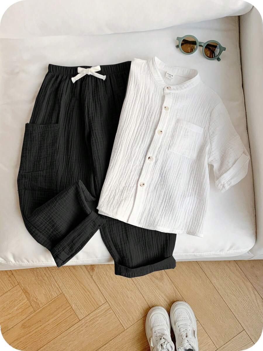 SHEIN 2 件装年轻男孩休闲运动度假套装，包括干净纯色白色 Polo 衫和带口袋的松紧腰纯色裤子，百搭舒适的服装，适合儿童、幼儿男孩、返校、生日、派对、表演、婚礼、情人节、日常穿着、学校、旅行、运动、春季和夏季 - 黑色 - 查看 1