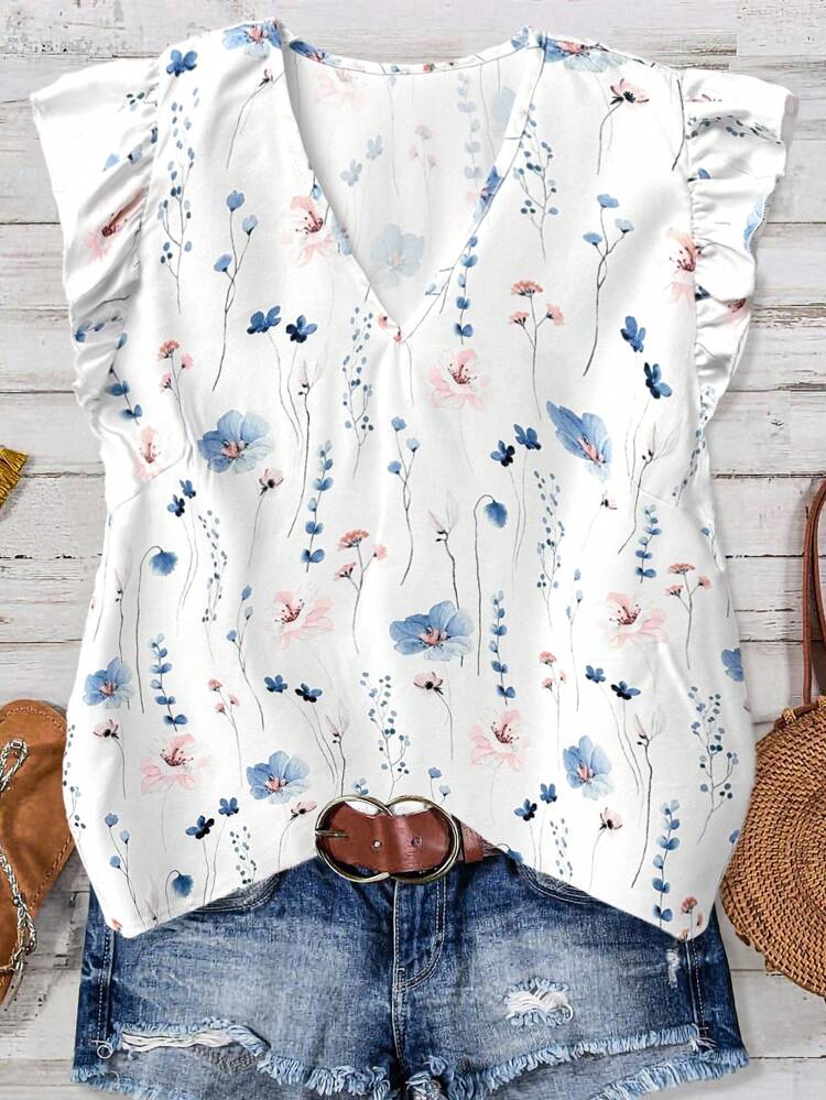 Schickes Damen-Top aus Polyester mit V-Ausschnitt und zartem Blumenmuster in Blau und Rosa auf Weiß. Erleben Sie Bohème-Flair mit der regulären Passform und den charmanten Rüschenärmeln – ideal für den Alltag. V-Ausschnitt-Blusen für Damen, Sommerblusen