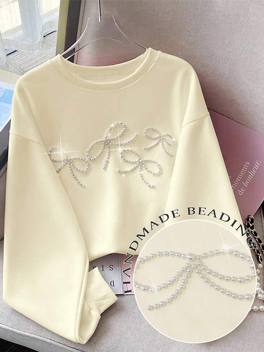 Resyla Áo nỉ cổ tròn dáng rộng có nơ đính hạt trang trí cho nữ - Màu be - Xem 1
