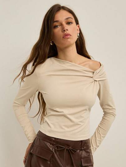 Nöista Top à manches longues avec épaules dénudées torsadées en jersey stretch doux, ajusté au torse avec un ourlet légèrement court pour une silhouette élégante et moderne. Parfait pour l'automne et les fêtes : à porter sous un manteau en laine ou avec un pantalon taille haute et des bottes à talons pour les fêtes de Noël, ou avec un collant et une jupe en velours côtelé pour des sorties de saison confortables.