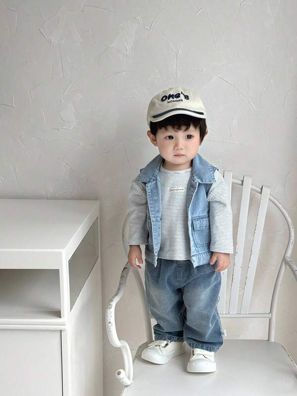 SHEIN Babyboy这款春秋款浅蓝色牛仔背心采用牛仔面料制成，厚度适中，宽松版型。古铜色纽扣复古又不失精致，翻领设计赋予其复古、时尚、酷炫、百搭的风格。两个口袋实用又增添一丝休闲气息。适合日常穿着、度假休闲、校园活动、街头酷炫造型、学习滑板、参加派对等。