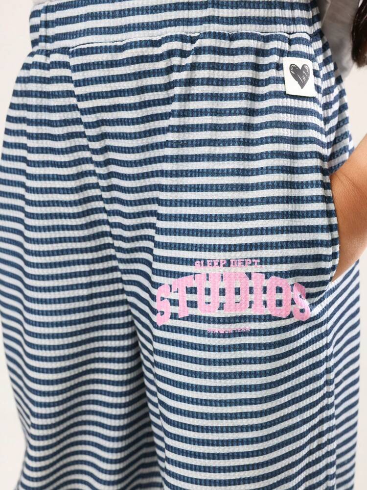 クロップド丈のスタジオTシャツとストライプのワイドレッグパンツ