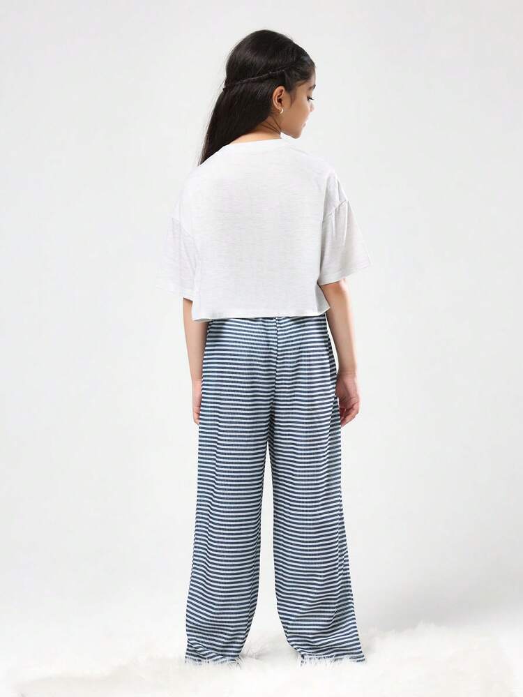 クロップド丈のスタジオTシャツとストライプのワイドレッグパンツ