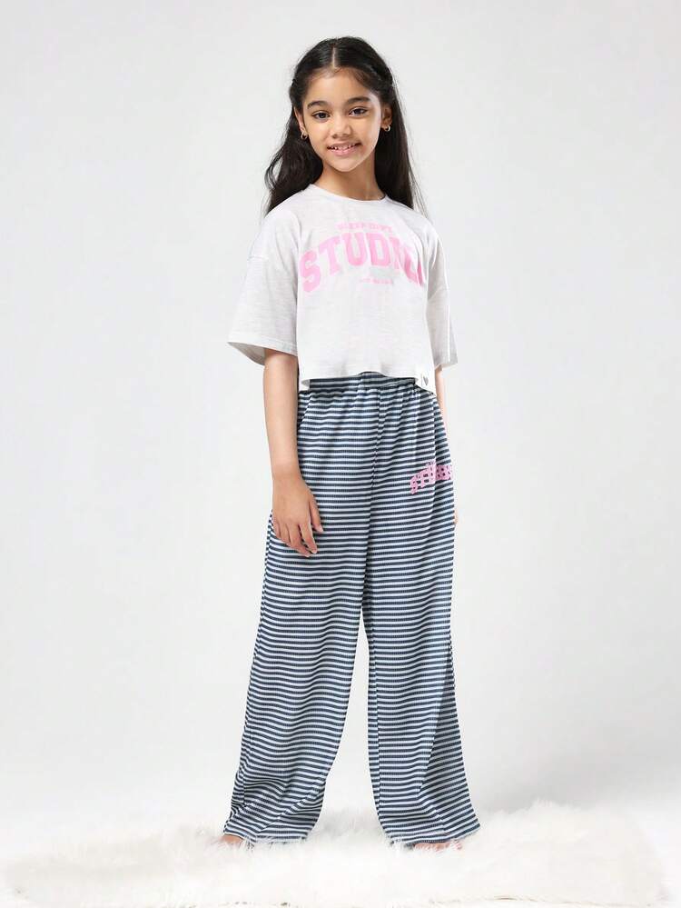 クロップド丈のスタジオTシャツとストライプのワイドレッグパンツ