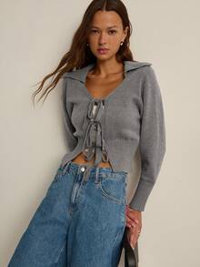 Nöista Áo khoác cardigan dệt kim dáng ngắn màu tím nhạt với cổ chữ V hở, cổ áo xẻ mềm mại và ba dây buộc phía trước. Cổ tay áo bo gân và cạp chun rộng tạo hiệu ứng tôn dáng. Hoàn hảo cho mùa thu, những buổi học tập hoặc những buổi hẹn cà phê thân mật. - Xám - Xem 7