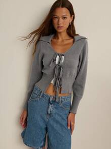 Nöista Áo khoác cardigan dệt kim dáng ngắn màu tím nhạt với cổ chữ V hở, cổ áo xẻ mềm mại và ba dây buộc phía trước. Cổ tay áo bo gân và cạp chun rộng tạo hiệu ứng tôn dáng. Hoàn hảo cho mùa thu, những buổi học tập hoặc những buổi hẹn cà phê thân mật. - Xám - Xem 6