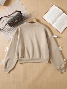 SHEIN 少女纯色撞色蝴蝶结装饰宽松休闲长袖圆领运动衫，适合假日穿着蝴蝶结运动衫带蝴蝶结的运动衫袖子上的蝴蝶结运动衫蝴蝶结袖子运动衫带丝带蝴蝶结的运动衫带白色蝴蝶结的运动衫袖子上的蝴蝶结运动衫蝴蝶结衣服衣服上的蝴蝶结毛衣带蝴蝶结的运动衫适合少女秋冬 - 杏色 - 查看 2