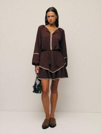 Nöista Mini Dress In Chocolate Brown Color,With Ruffle Hem And Tasseled Tie Neckline With Contrast Trimming. Spring, Summer Looks, Casual Outfit For Women.