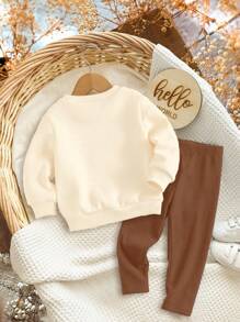 SHEIN Bộ đồ 2 món Happikins màu trắng kem in hình bí ngô và nơ dễ thương, áo nỉ dài tay dáng rộng thoải mái và quần skinny, thích hợp cho mùa thu/đông, chủ đề bí ngô Halloween, trang phục mùa thu, thoải mái dễ chịu, đồ nhiều lớp mùa thu cho bé gái, phong cách thời trang cho bé gái, trang phục thường ngày, quần áo in hình cho bé gái, trang phục mùa thu. - Nhiều màu - Xem 2