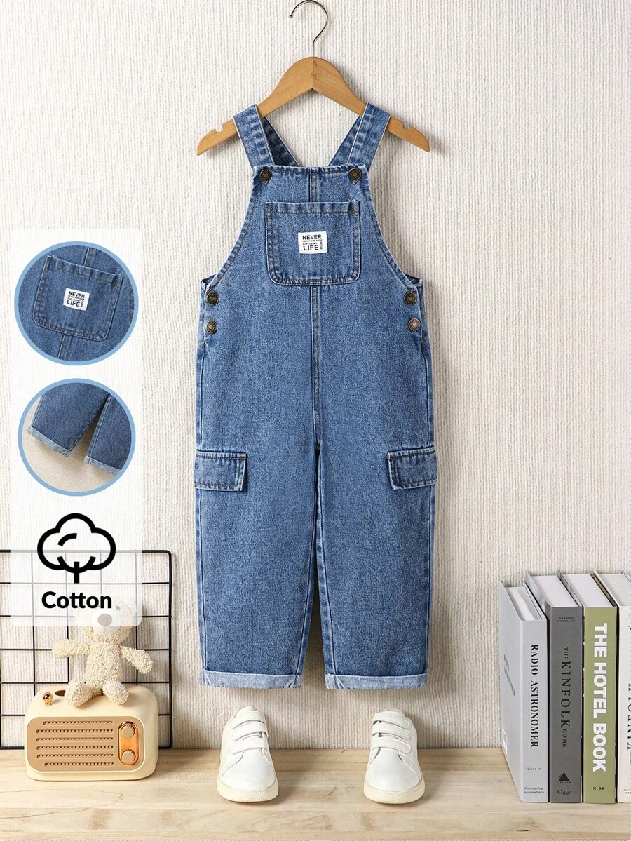 SHEIN Playful Pals 男童牛仔背带裤，复古美式学院风休闲装推荐，中蓝色水洗牛仔布，前袋上的品牌贴片增添酷感，侧面有仿口袋，合身舒适的廓形，反向下摆设计，可调节肩带，衣橱必备牛仔背带裤