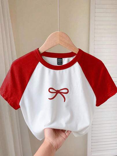 Comfortcana Camiseta de manga corta casual con cuello redondo, ajustada y acortada, de manga raglán, en color rojo y blanco, con estampado de lazo rojo