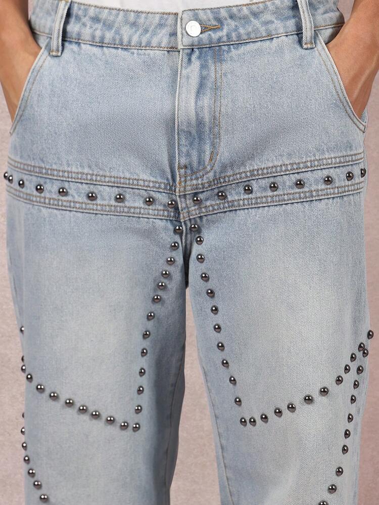 Pantaloni in denim a gamba larga con borchie e motivo geometrico