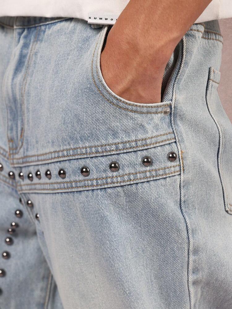 Pantaloni in denim a gamba larga con borchie e motivo geometrico