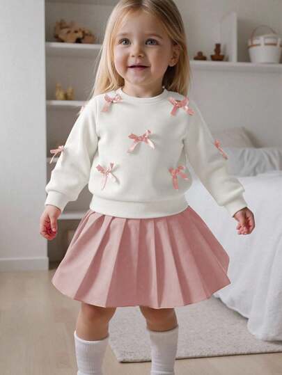 SHEIN Playful Pals 女婴休闲可爱两件套，黄色长袖运动衫搭配桃色蝴蝶结装饰，搭配浅棕色百褶裙，适合日常穿着、上学、摄影、聚会、春秋季