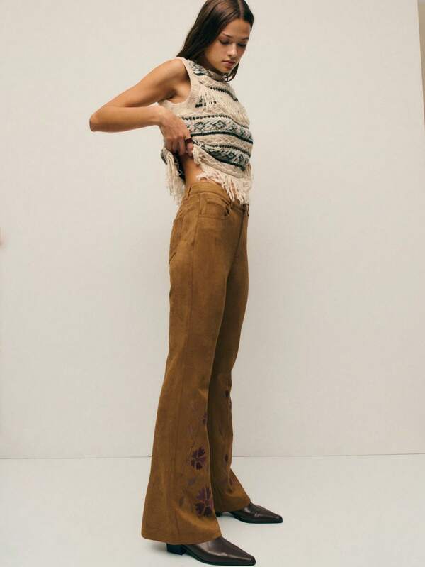 Nöista Brown Suede Flared Pants With Detailed Floral Embroidery, Combining Comfort With A Refined Bohemian Touch; A Stylish Option For Elegant Winter Outfits, Standout Seasonal Looks, Festive Christmas Dressing And Sophisticated New Year Styling.
