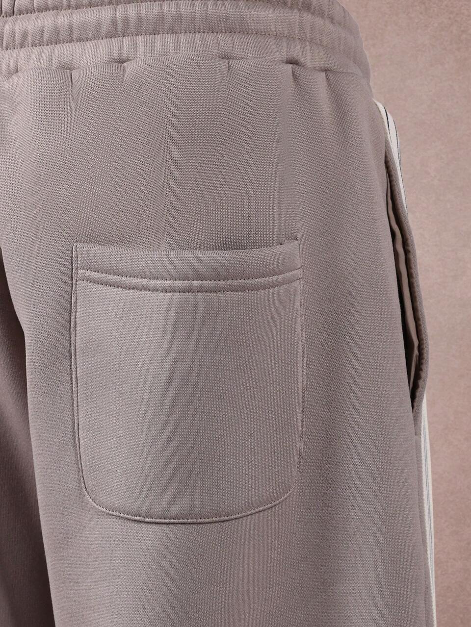 Pantalones deportivos de pierna ancha con detalle de raya lateral