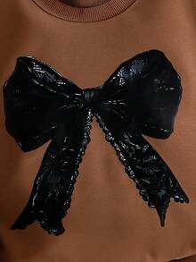 SHEIN Elladie kids 两件套女童棕色蝴蝶结印花长袖上衣搭配黑色喇叭裤套装，可爱舒适的卫衣套装，适合春秋冬季穿着。