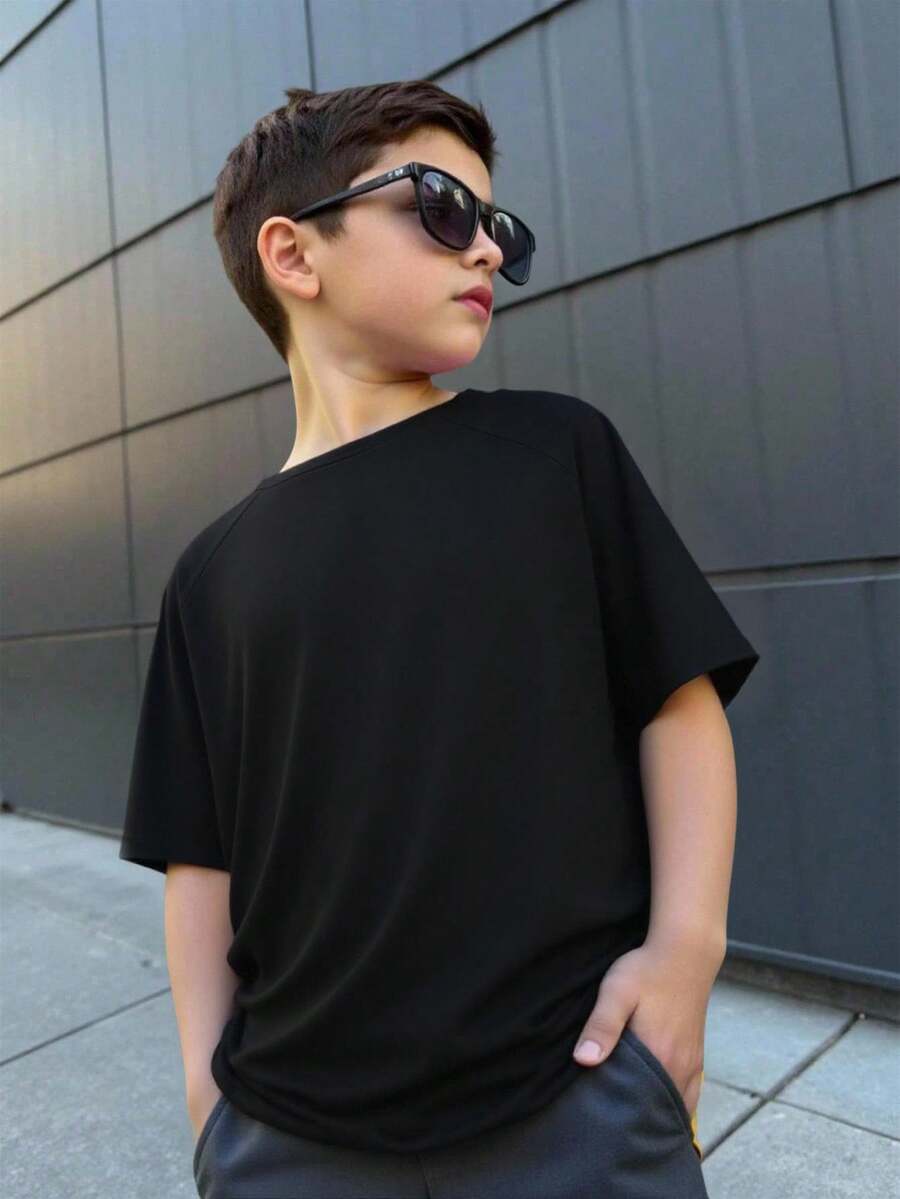 SHEIN Camiseta de manga corta con cuello redondo minimalista y holgada de unicolor con mangas raglán para niño preadolescente - Negro - Ver 1