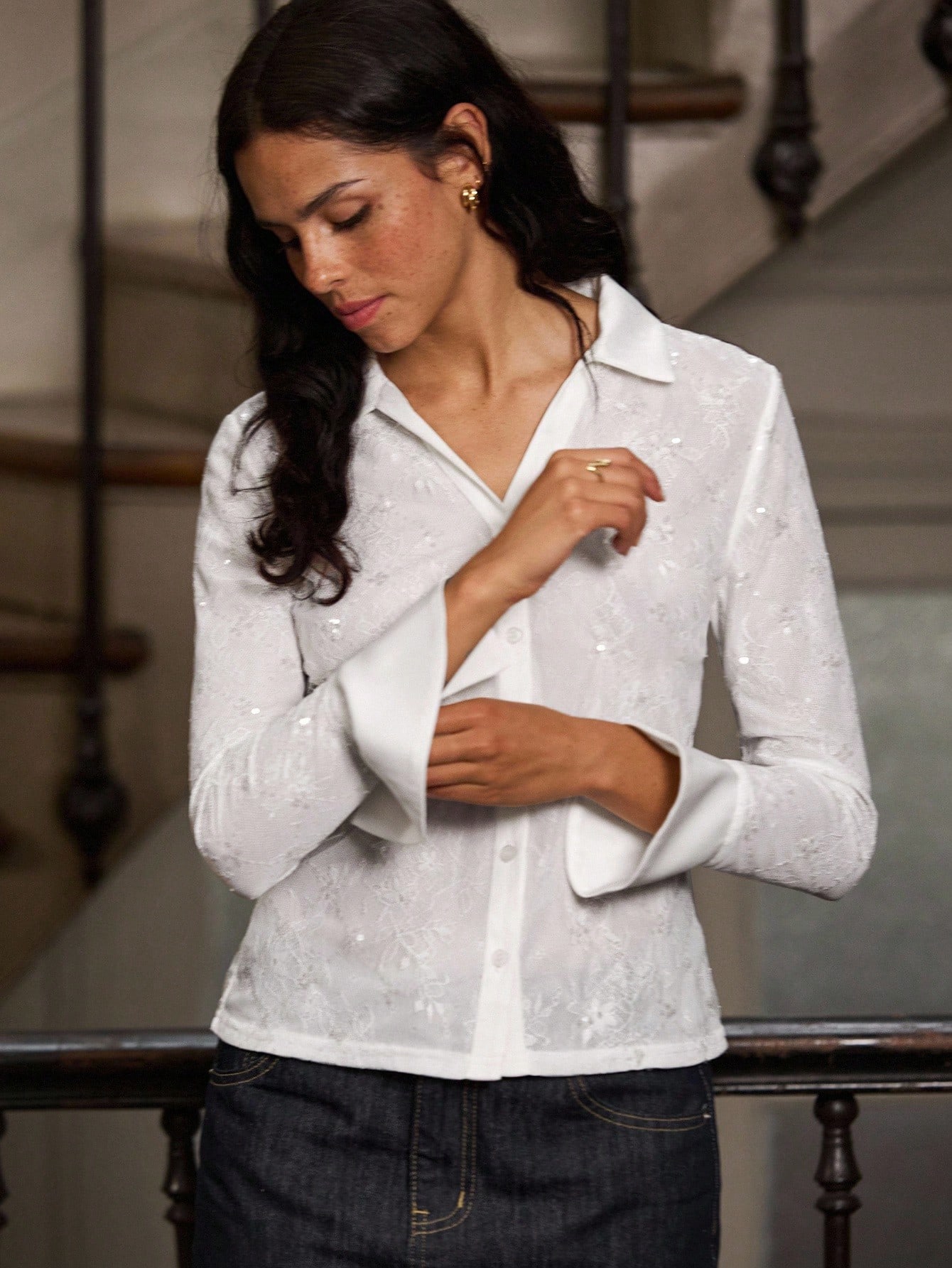 Dopasowana biała koszula z koronkowym korpusem, cekinami na kołnierzyku i rozkloszowanymi mankietami. Jesienne ubrania damskie na jesień i zimę.