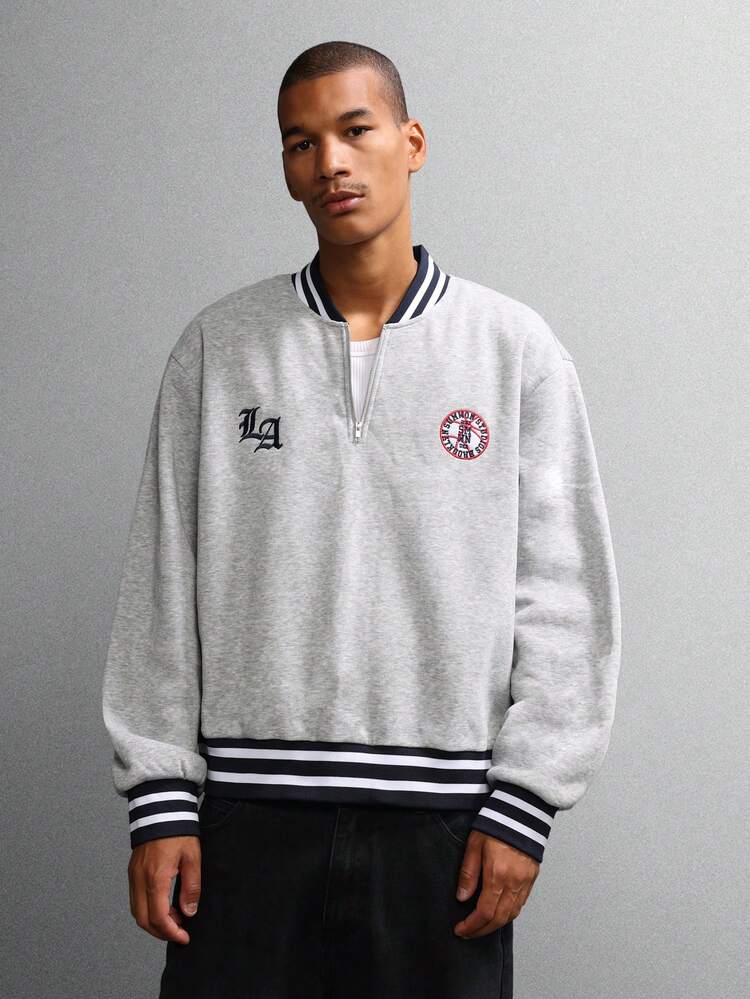 바시티 트림과 로고 디테일이 있는 하프 지퍼 스웨트셔츠