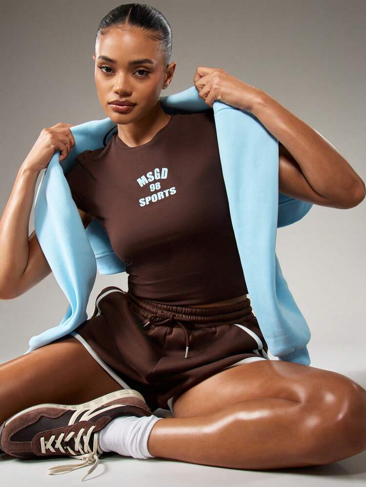MISSGUIDED Camiseta deportiva de bebé de color marrón chocolate con estampado de texto en azul claro, top corto de manga corta para uso casual