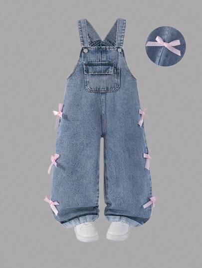 年轻女孩复古中蓝色水洗牛仔背带裤，蝴蝶结装饰，宽松直筒版型，面料柔软舒适，休闲百搭，女孩牛仔裤
