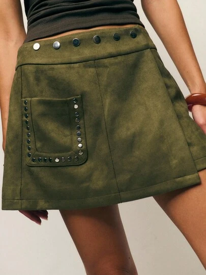 Nöista Olive Faux-Suede A-Line Mini Skirt With A Studded Waistband And Rivet-Trim Patch Pocket For A Subtly Retro, Slightly Utilitarian Finish. Soft, Structured Faux-Suede Gives Shape Without Stiffness; Clean Topstitching And A Neat Hem Keep The Silhouette Polished And Easy To Style. Perfect For Autumn And Holiday Dressing.