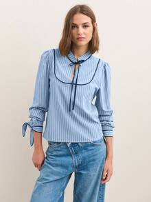 Nöista Blusa de manga larga a rayas con ribete de contraste y un suave cuello con volantes - Una elegante y chic blusa de otoño/invierno. Las rayas verticales y un cuello con lazo le dan un toque refinado y ligeramente vintage, mientras que las suaves mangas abullonadas y los puños recogidos crean una silueta pulida ideal para combinar con otras prendas.